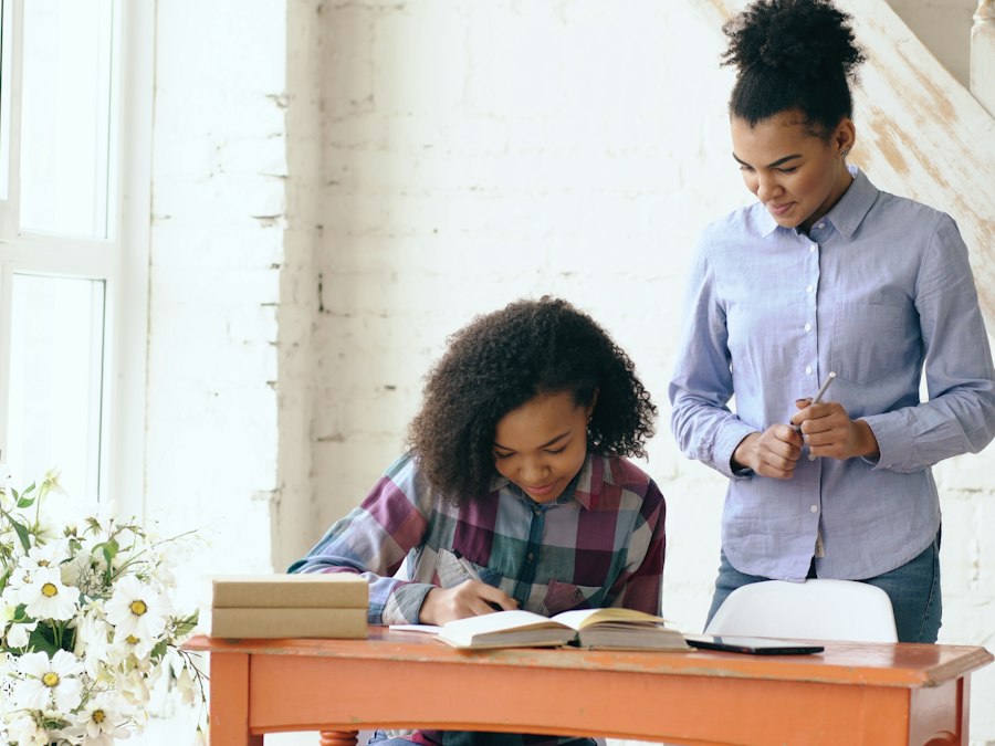 Begeleider helpt een jongere met leren aan een bureau