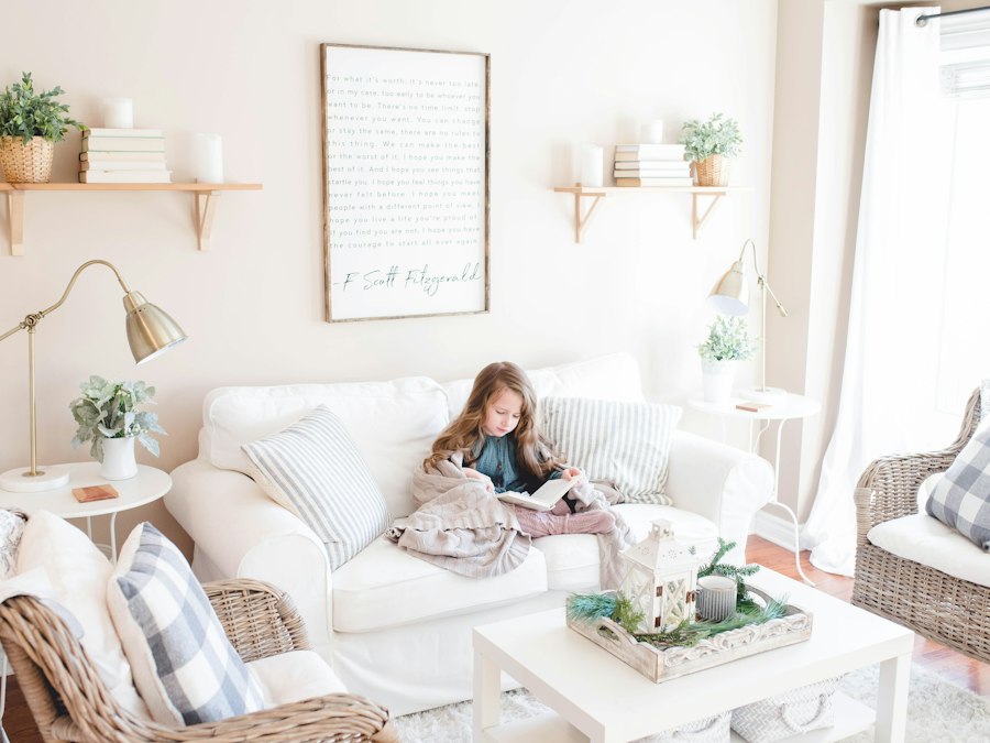 Jongere leest op de bank in een huiselijke woonkamer