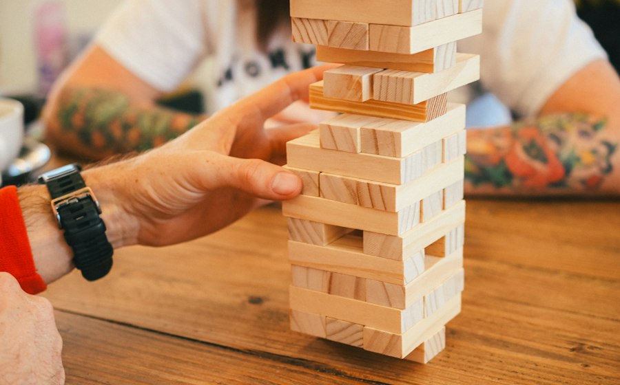 Handen bouwen samen aan een houten toren